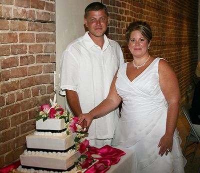 bride and groom in front of their wedding cake